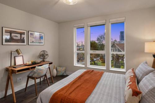 a bedroom with a bed and a desk and windows at New House in peaceful and trendy Central District in Seattle