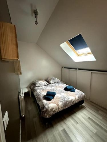 a bedroom with a bed with blue pillows on it at Belle maison à la campagne in Colligis-Crandelain