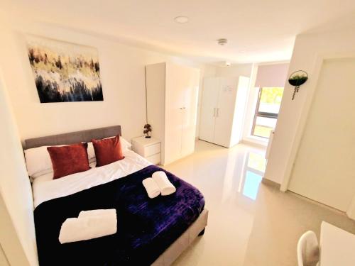 a bedroom with a large bed with red pillows at En-suites Suites - Leeds City Retreat with Kitchenette- LGI Hospital- Free 5G WIFI & Netflix- University - Contractors - Short Stays in Leeds