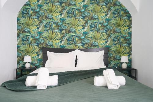 a bedroom with a bed with a blue and green wallpaper at NatureHouse in Campo Maior
