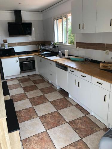 a kitchen with white cabinets and a tiled floor at Villa del catalunya in Perpignan