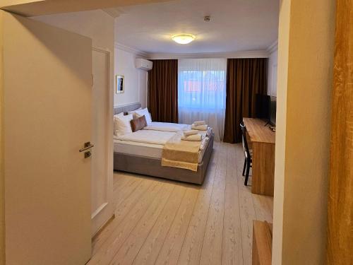 a bedroom with a bed and a desk and a television at Hotel Royal Plaza By TimHotels in Timişoara