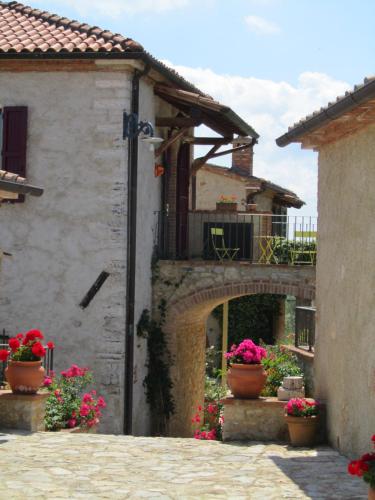 an old stone building with flower pots in an alley at Agriturismo Borghetto Il Montino in Rapolano Terme