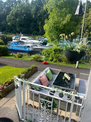 a balcony with a garden with boats in a marina at Loch Lomond Riverside Apartments A in Balloch