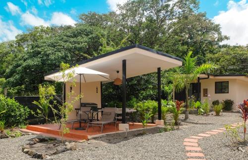 a small house with a patio and an umbrella at MY - Cosy Lodges in Paraíso