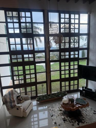 a living room with a large room with large windows at Hotel MACA lago calima in Calima
