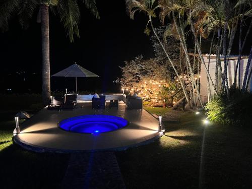 a blue pool in the middle of a yard at night at Hotel MACA lago calima in Calima