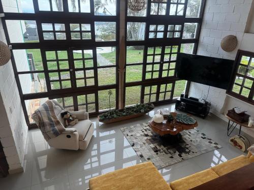 a living room with a lot of windows and a tv at Hotel MACA lago calima in Calima