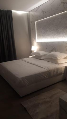 a bedroom with a white bed and a light at غرفة فاخرة مع دورة مياه ومطبخ بحي الضاحية in Arar