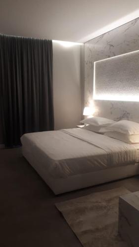 a bedroom with a white bed and a light at غرفة فاخرة مع دورة مياه ومطبخ بحي الضاحية in Arar