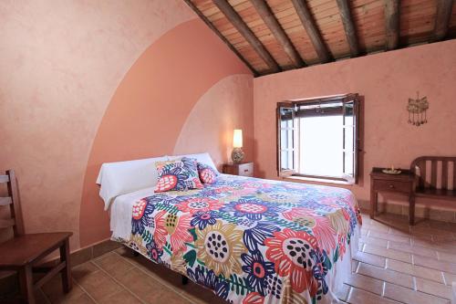 a bedroom with a bed in a room with a window at Casa del Río by SIERRA VIVA in La Nava