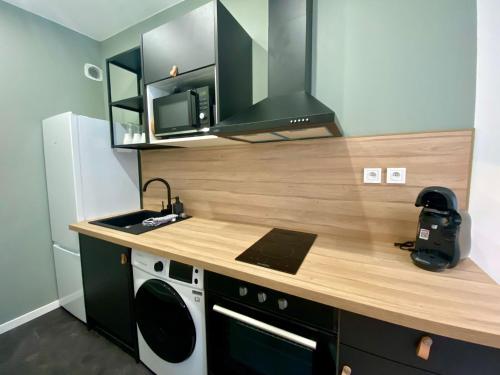 - une cuisine avec un comptoir, un évier et une cuisinière dans l'établissement Appartement rempli de douceur - 350, à Rouen