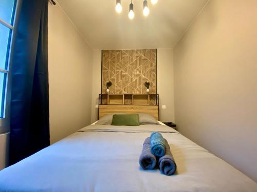 une chambre avec un lit avec des serviettes bleues dessus dans l'établissement Appartement rempli de douceur - 350, à Rouen