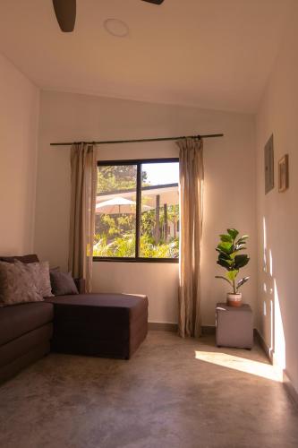 a living room with a couch and a window at MY - Cosy Lodges in Paraíso