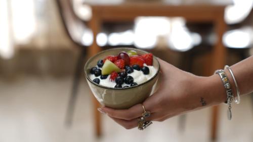 a person holding a bowl of fruit salad at Hotel Lepelbed in Ghent