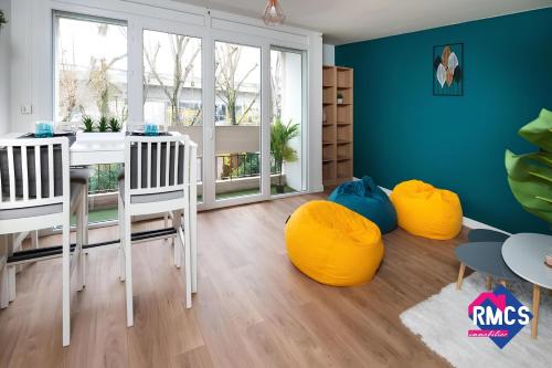 une salle à manger avec une table et des chaises jaunes dans l'établissement Île Lacroix Appart spacieux et lumineux Rouen 