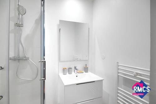 une salle de bain blanche avec un lavabo et un miroir dans l'établissement Île Lacroix Appart spacieux et lumineux Rouen 