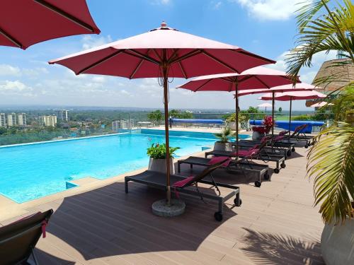 a row of chairs and umbrellas next to a swimming pool at Skynest Residences by Lisa's Paradise A in Nairobi