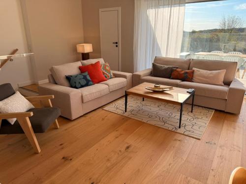 a living room with two couches and a coffee table at Elegantes Ferienhaus Seeidylle mit Blick auf Möhnesee in Möhnesee
