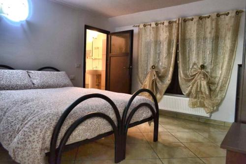 Pensiunea Lui Nea Nicu Lepsa في ليبسا: غرفة نوم بسرير ونوافذ مع ستائر