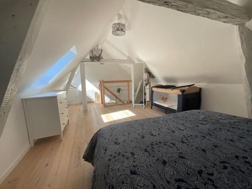 - une chambre mansardée avec un lit et un escalier dans l'établissement Amelie - petite maison alsacienne, à Blotzheim