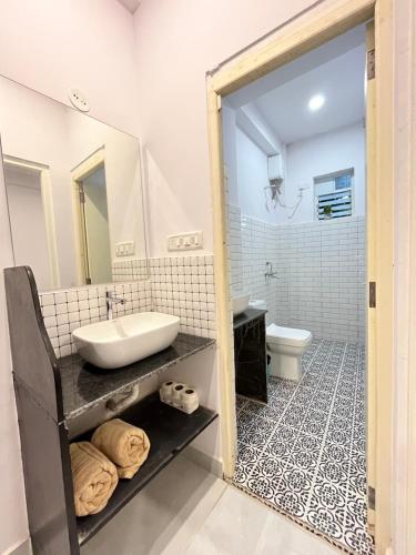 a bathroom with a sink and a toilet at V R Holiday Home in Candolim