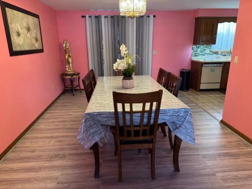 a dining room with pink walls and a table with chairs at Full House/Heart of Worcester in Worcester