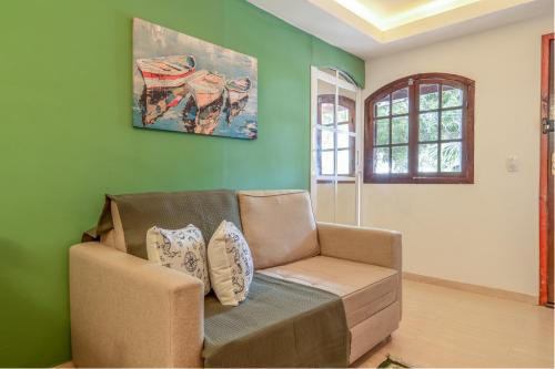 a living room with a couch and a painting on the wall at Pousada Portal de Búzios in Armacao dos Buzios