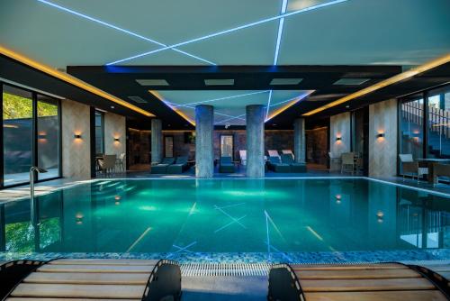 a swimming pool in a hotel with chairs and tables at HOTEL ROYAL MOUNTAIN in Divčibare
