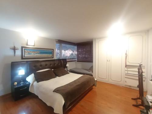 sypialnia z dużym łóżkiem i oknem w obiekcie Habitación con baño privado, Norte de Bogotá w mieście Bogota