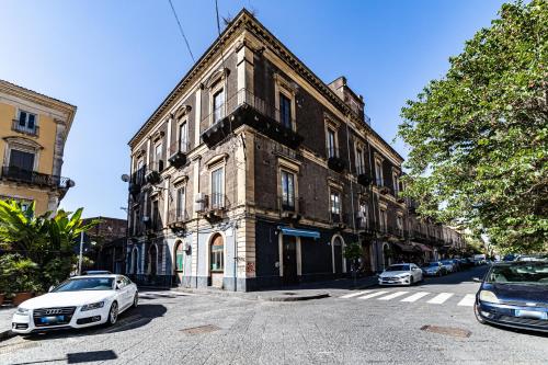 an old building with cars parked in front of it at Malìa Home in Catania