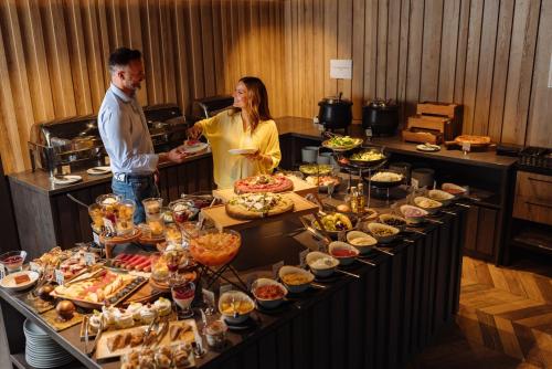 a man and woman standing in front of a buffet of food at HOTEL ROYAL MOUNTAIN in Divčibare
