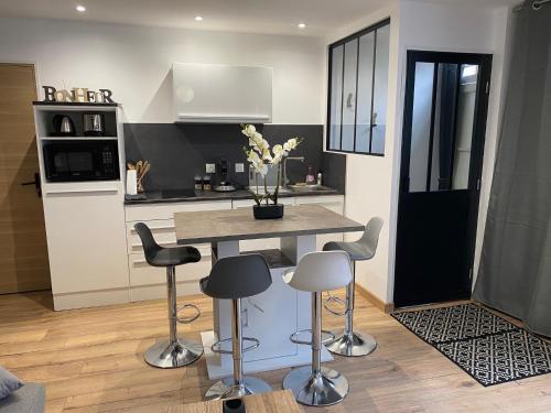 une cuisine avec une table et des tabourets dans une pièce dans l'établissement Maison aux portes de Chambord-zoo Beauval 40 mn, à Bracieux