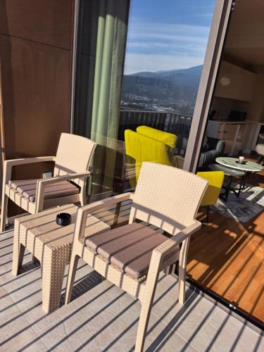 two chairs and a table and chairs on a balcony at Anika Luxury apartment at Diamond center in Skopje