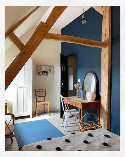 Cette chambre est dotée d'une table en bois et d'un mur bleu. dans l'établissement Domaine de Ronsard, à Dame-Marie