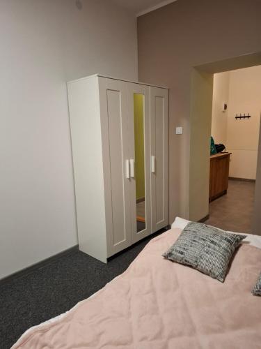 a bedroom with a large bed and a cabinet at Apartament Maja in Bielsko-Biała