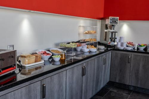 Rancho de la CruzにあるHotel 5 Inn Selectのカウンターの上にたくさんの食べ物が置かれたキッチン