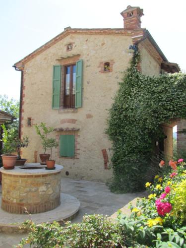 an old house with a fountain in front of it at Agriturismo Borghetto Il Montino in Rapolano Terme