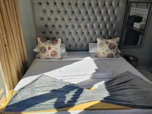 a bed with a headboard and a blanket on it at A47 self catering apartment inside Bains Lodge in Bloemfontein