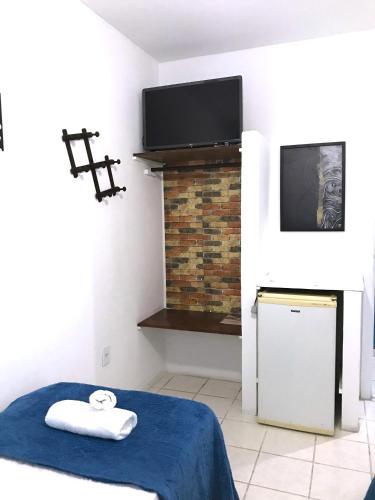 a room with a bed and a tv and a fireplace at Pousada Turquesa By Gente Bonita in Búzios