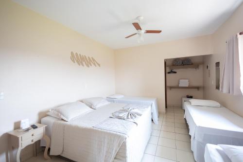 a bedroom with two beds and a ceiling fan at Pousada Mirante das Estancias in Águas de Lindóia