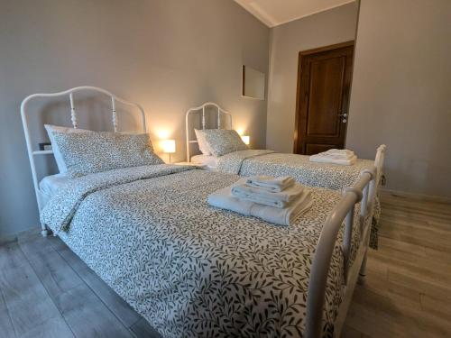 two beds in a bedroom with towels on them at La casa di Jo in Navacchio