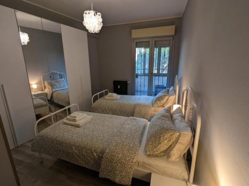 a small bedroom with two beds and a mirror at La casa di Jo in Navacchio