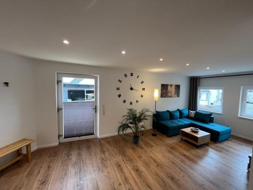 un salon avec un canapé bleu et un réveil dans l'établissement Al Backstuff, à Hambuch