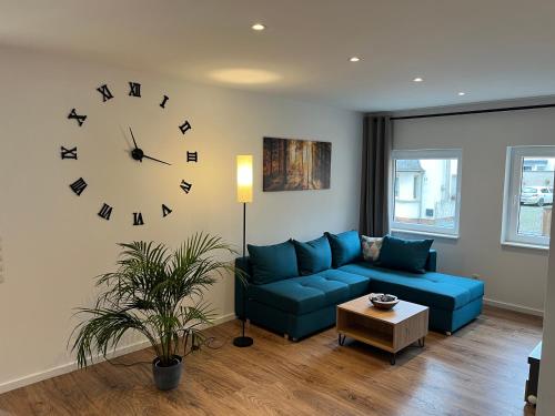 un salon avec un canapé bleu et un réveil dans l'établissement Al Backstuff, à Hambuch