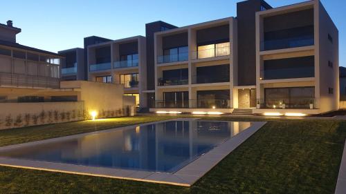 a building with a swimming pool in front of it at Marinhas Nature in Marinhas