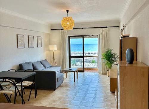 a living room with a couch and a table at T1 Vista Baía Monte Gordo in Monte Gordo