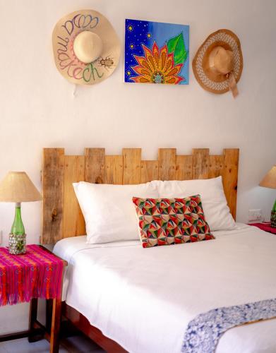 a bedroom with a white bed with hats on the wall at Departamentos privados In Wotoch in Valladolid