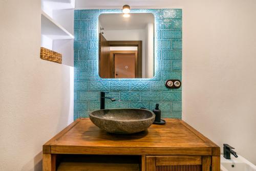 a bathroom with a stone sink and a mirror at La Posada del Gato Carataunas in Carataunas
