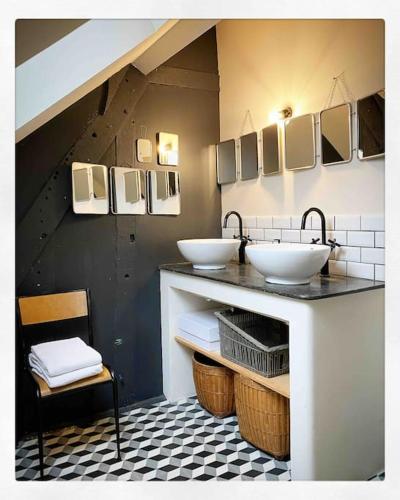 une salle de bains avec deux lavabos sur un comptoir avec un escalier dans l'établissement Domaine de Ronsard, à Dame-Marie